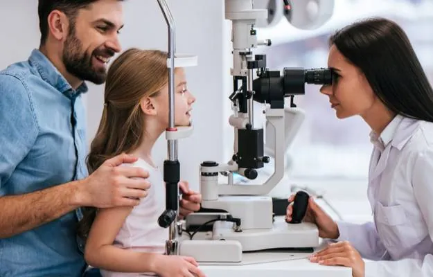 eye doctor is checking eyes for kid with dad behind What Is Myopia In Children How To Control It body ss
