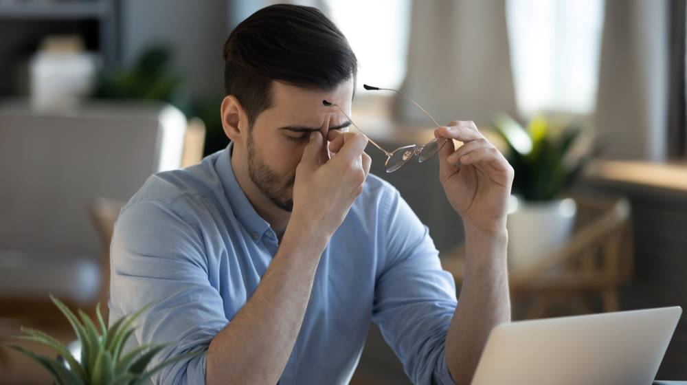 guy with dry eyes holding eyeglasses Everything You Need to Know About Dry Eye Syndrom feat ss