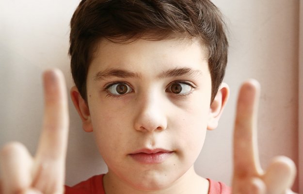 preteen-handsome-boy-play-squinting-trick-with-his-eyes-and-fingers-close---Diagnoses-and-Treatments---ss-body
