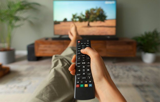 Woman-watching-TV-at-home-and-holding-the-remote-control-What-Is-Blue-Light-as-body